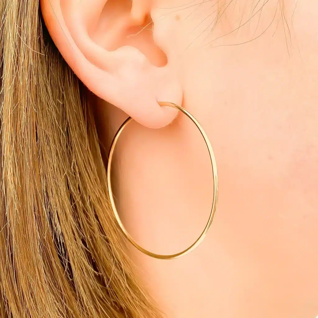 a blonde hair women wearing gold large hoops