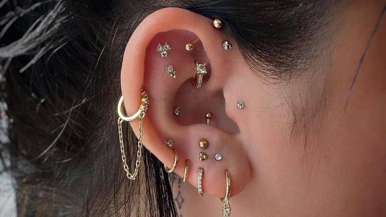 a girl is wearing differnet ear peices in ear