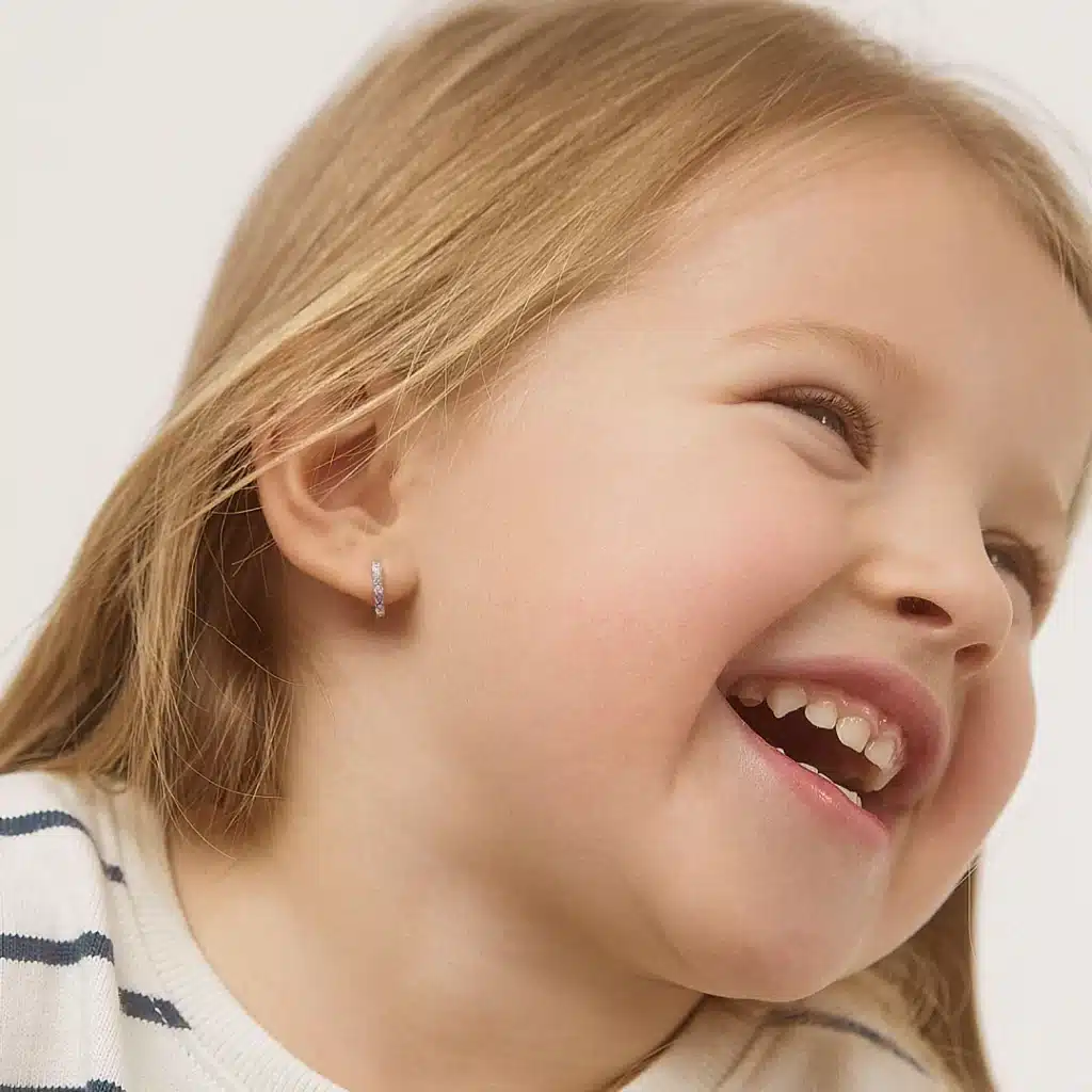 a little girl wearing silver earrings