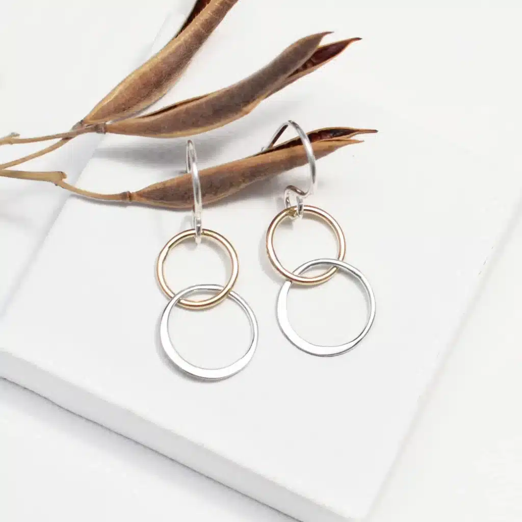 a paoir of white and gold dangle earrings