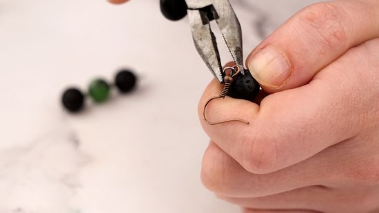 a person putting earrings hanging with a tool