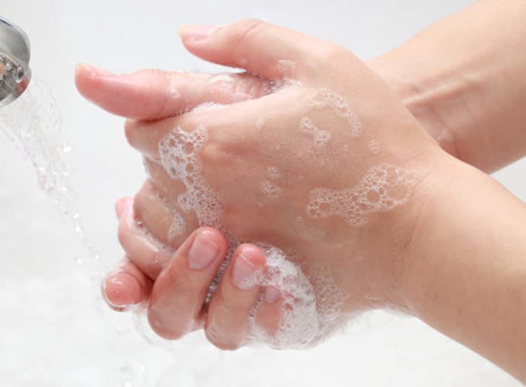 a women is washing her hands with soap