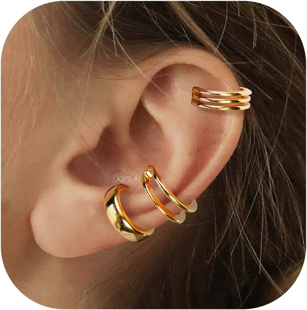 a women wearing three gold ear cuffs