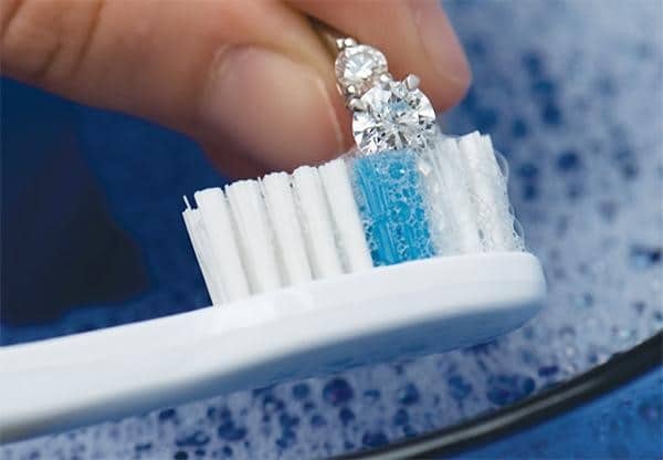 cleaning of diamond earrings with brush