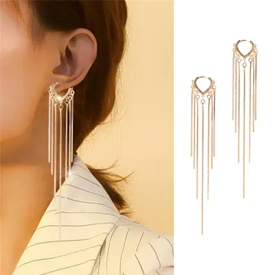 a lady wearing gold tussle drop earrings with the earrings front view image 