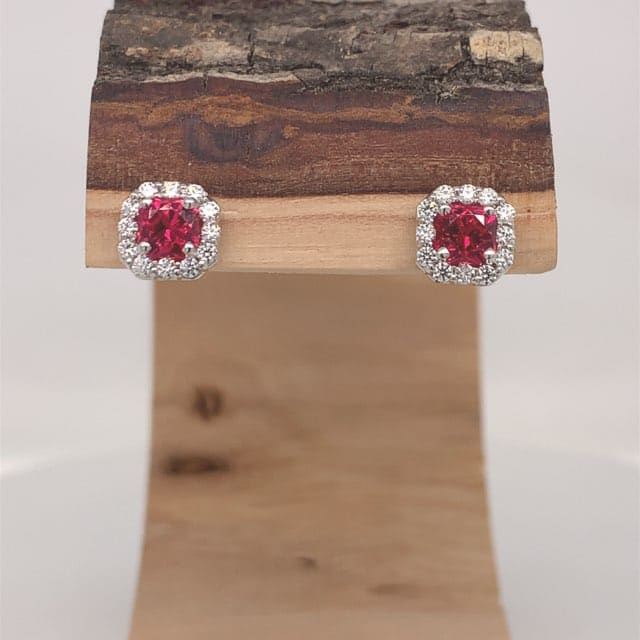 a pair of red Artificial Spinel Earrings held on a wooden support