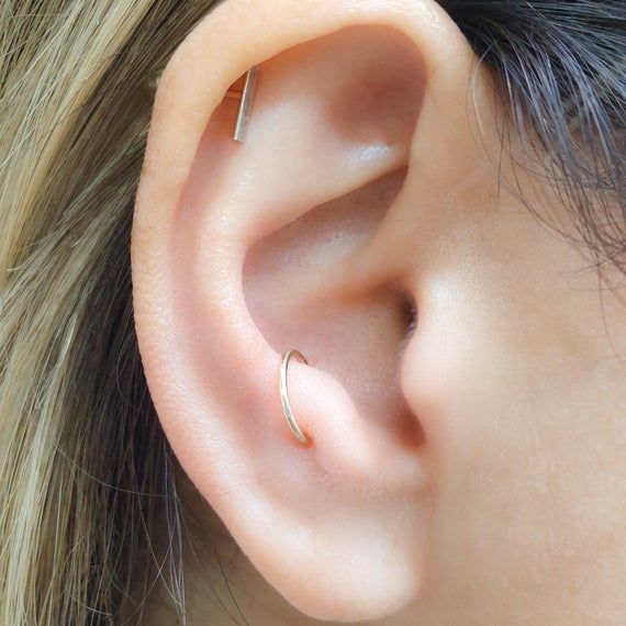 ear of a lady having Bold Anti Tragus Piercings