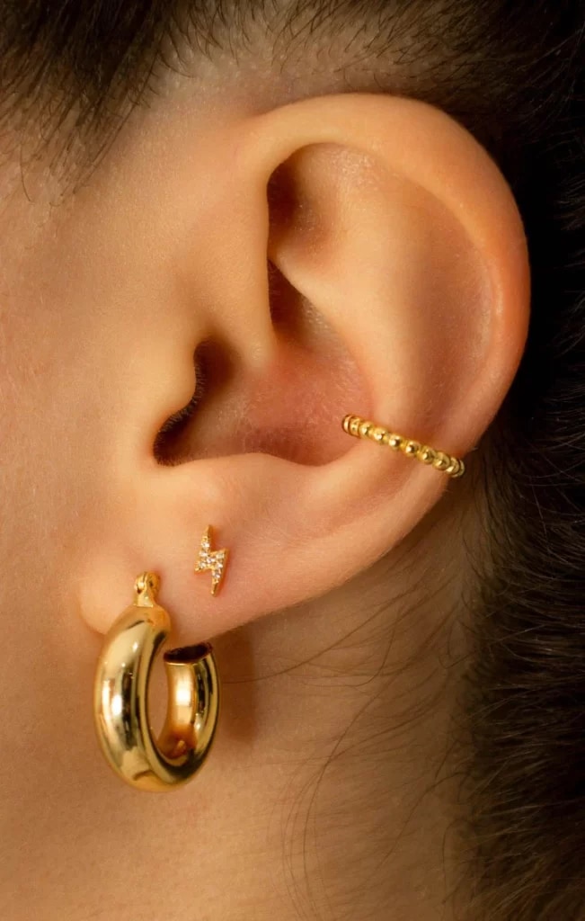 an ear with hoop earing , stud earring and Conch Piercing Cuffs