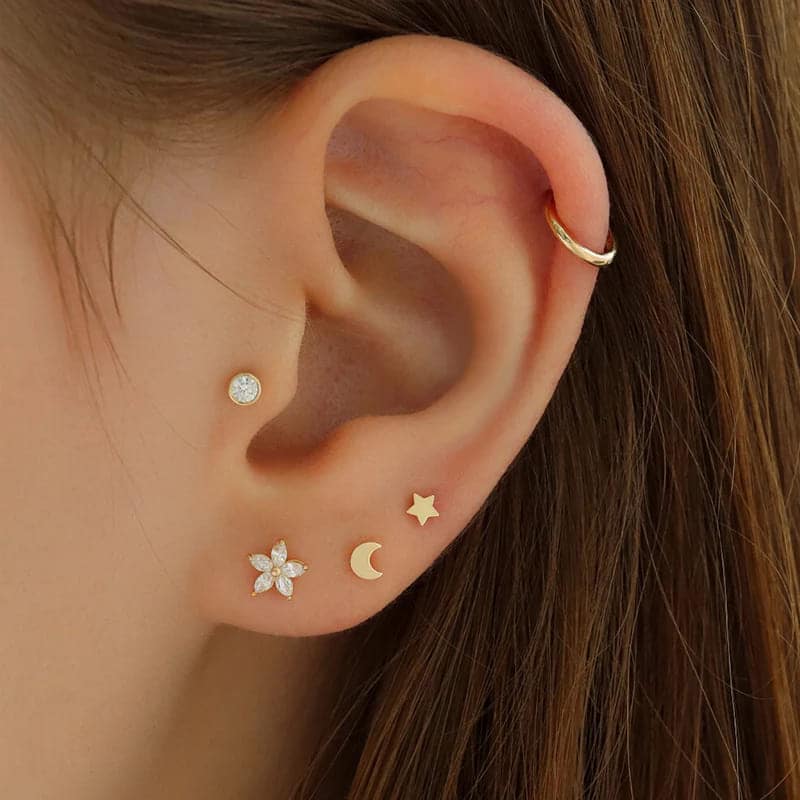 a girl earing different kinds Elegant Gold Cartilage Studs in an ear