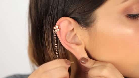 a lady trying to Put on Ear Cuffs