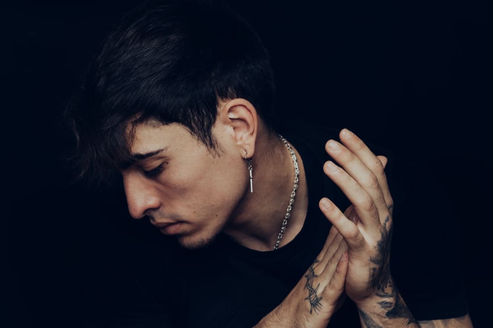 Portrait Of A Young Man With Tattoos And Earrings Clapping