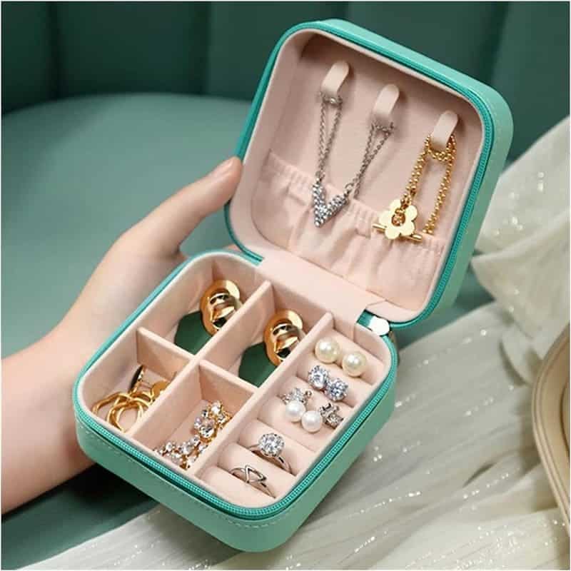 an open jewelry box in blue color with jewelry pieces organized inside