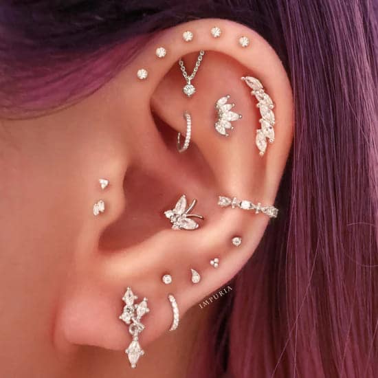 an ear of a lady having wearing cartilage piercing jewelry 