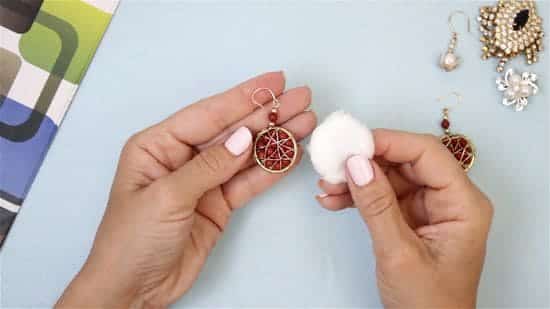 a lady cleaning her earring with a cotton swab