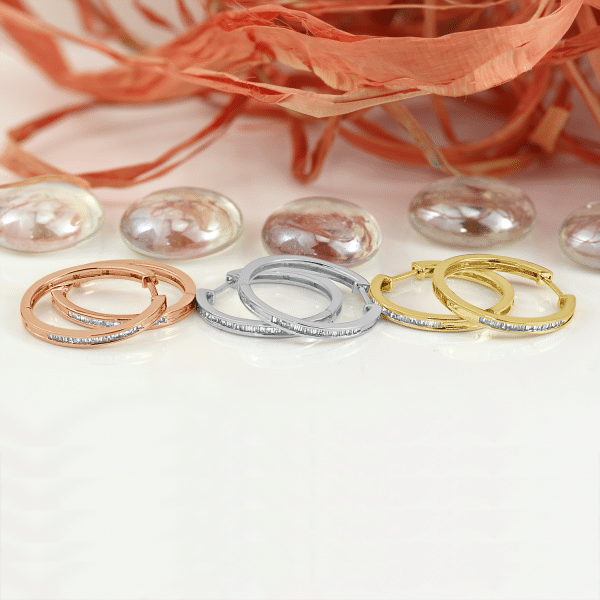 three pair of colorful huggies earrings placed on a white floor