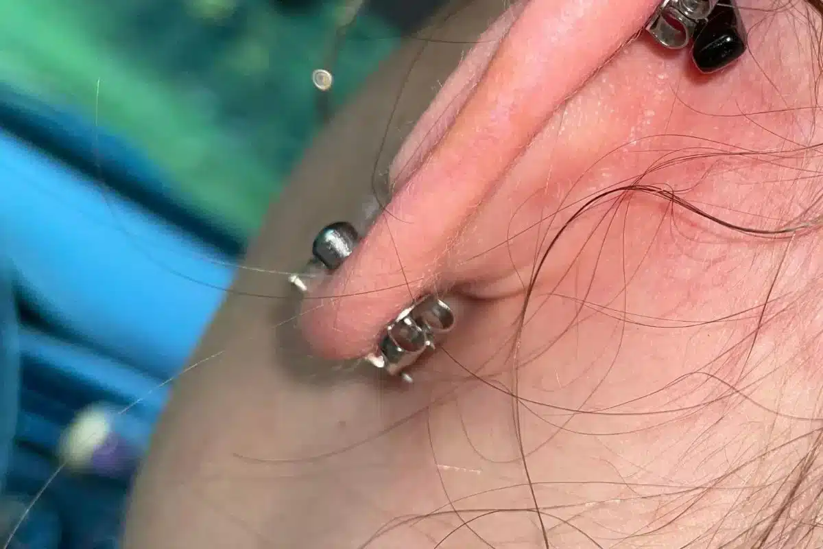 A girl wearing butterfly back earring close up view