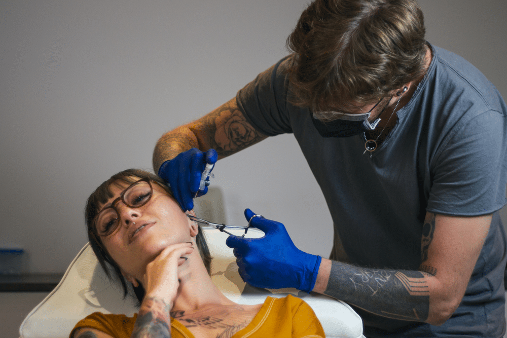 a lady getting her ear piercing