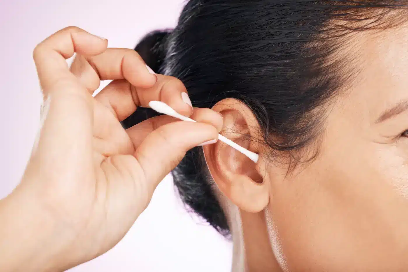 a woman cleaning ear with cotton swab