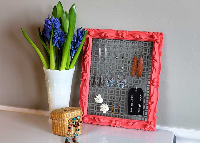 metal earring holder with a planter placed nearby