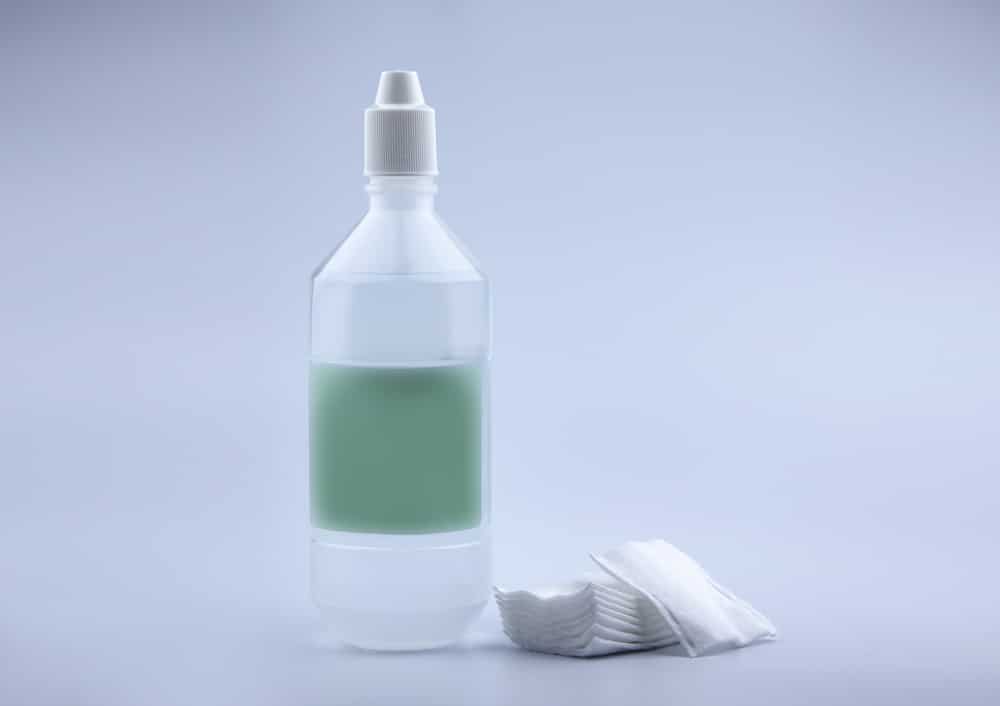 Saline Solution And Medical Cotton On A White Background