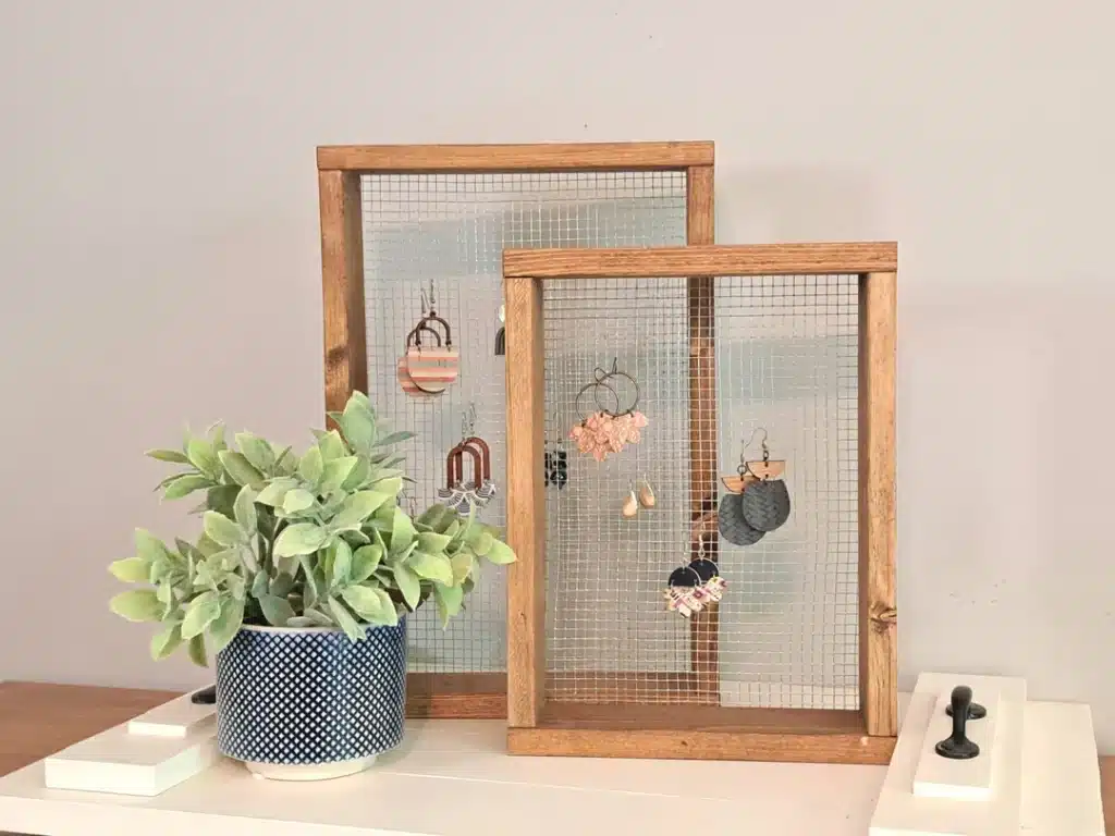 two chicken wire earring holders on a table