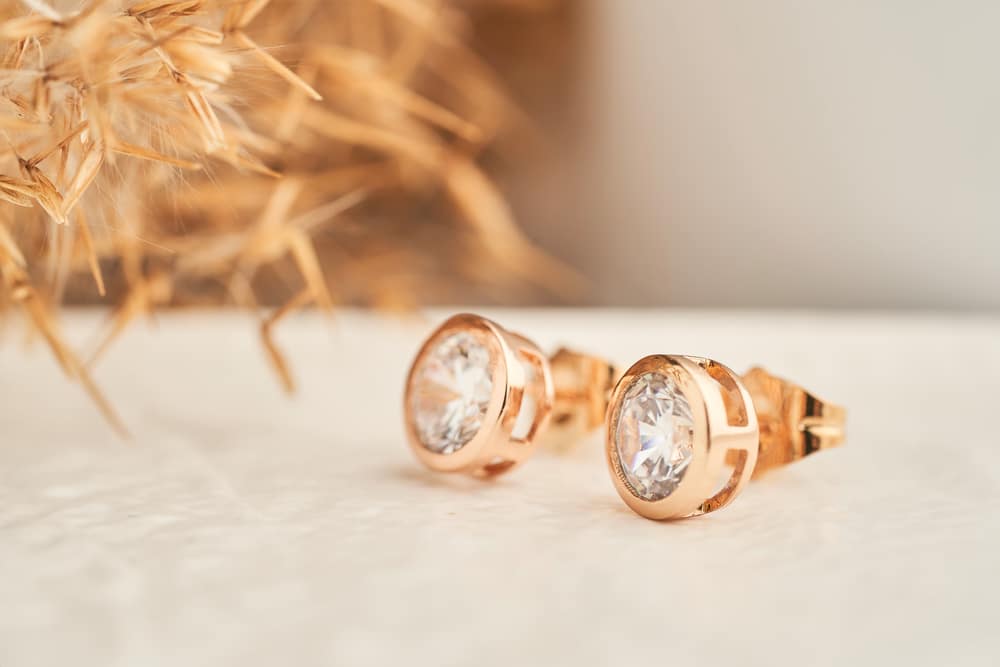 Close Up Golden Stud Earrings With White Crystals And Diamonds