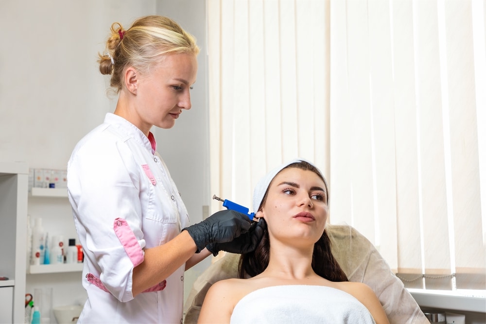 Specialist Pierces The Client's Ears With A Piercing Gun 