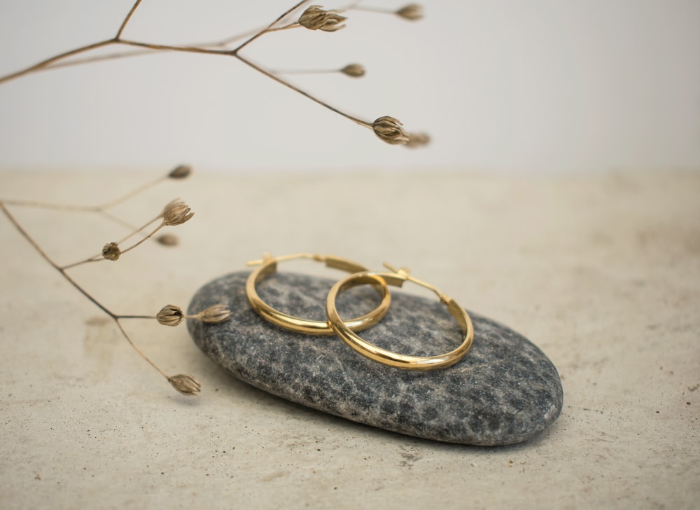 gold earrings on a stone