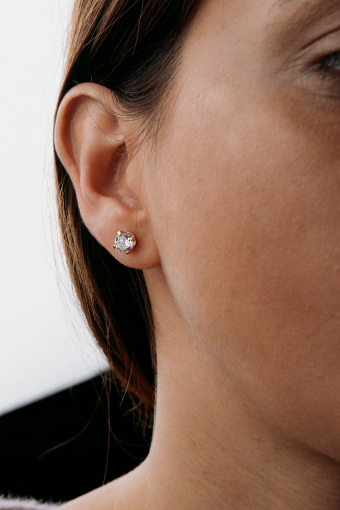 A view of a woman wearing diamond studs