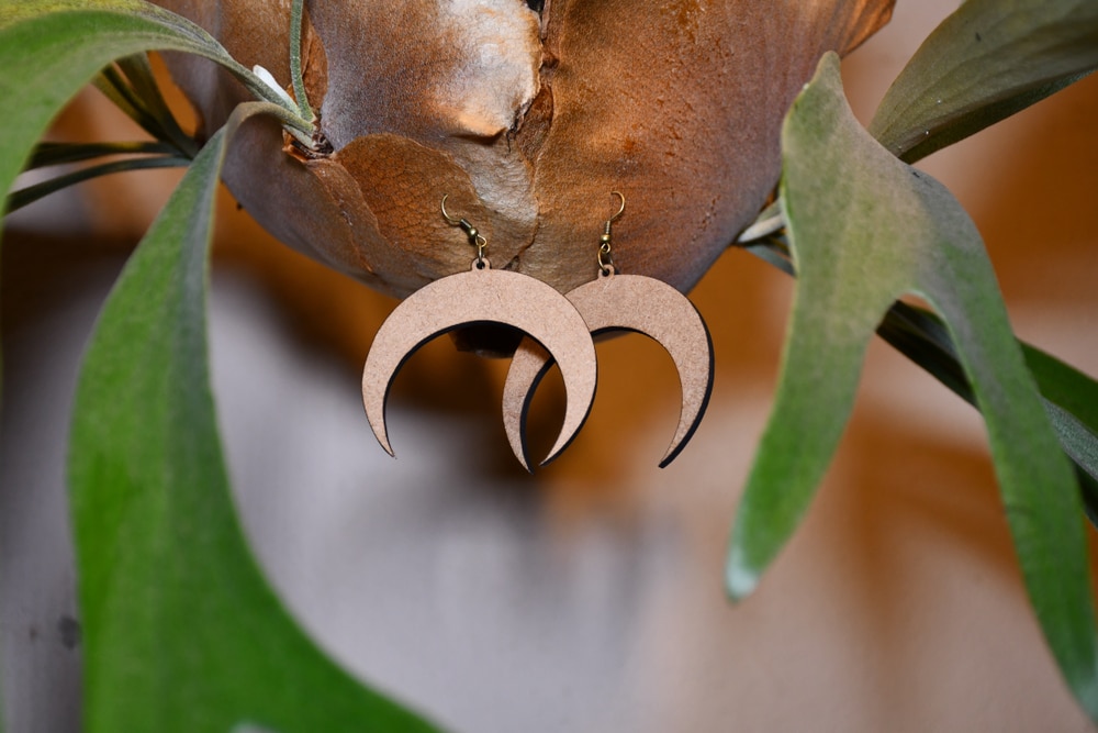 A view of moon shaped laser cut wooden earrings