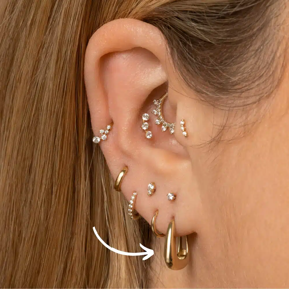 close up of an ear with several piercings