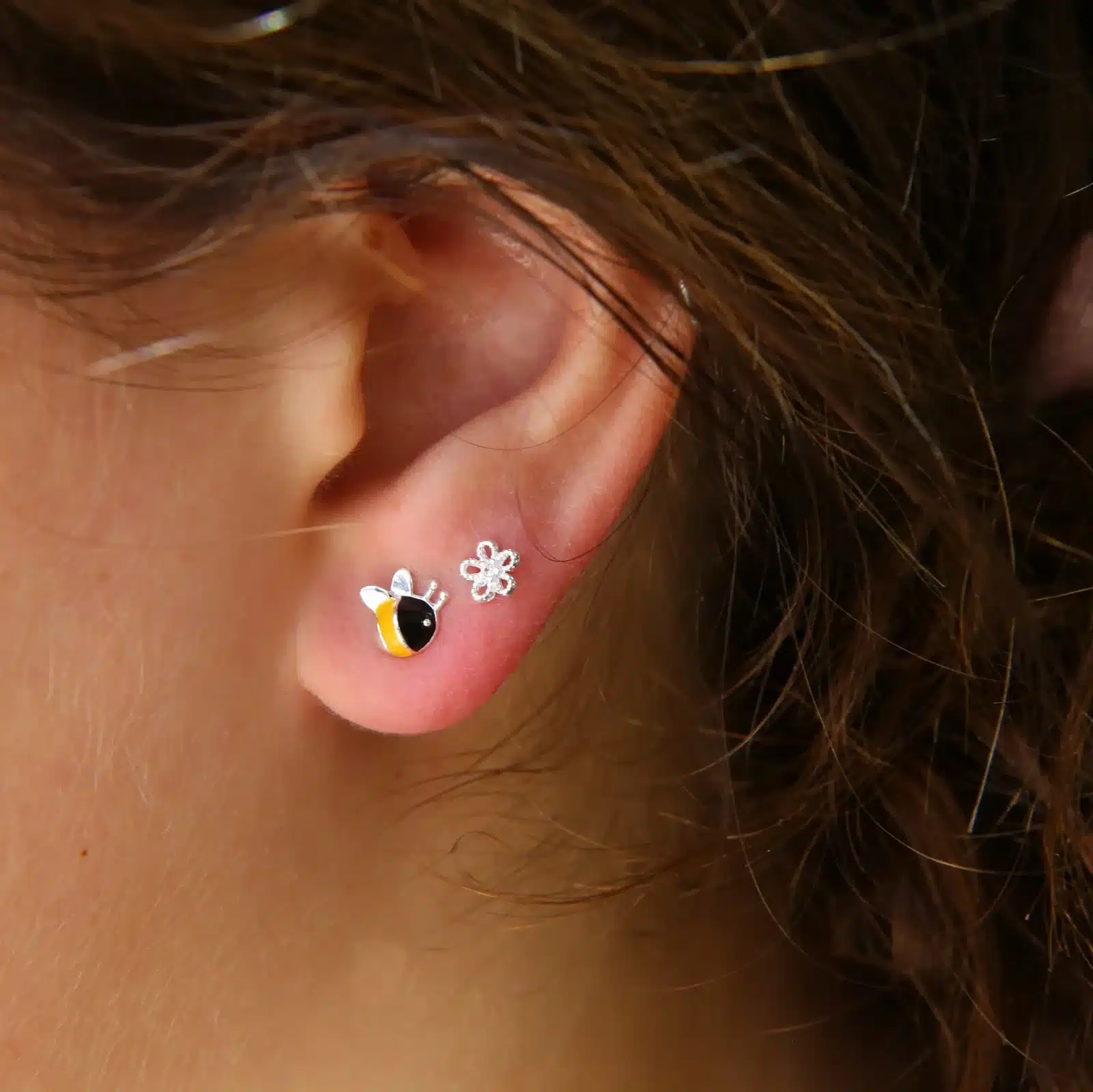 zoomed view of red ear with metal earrings zoomed view of red ear with metal earrings