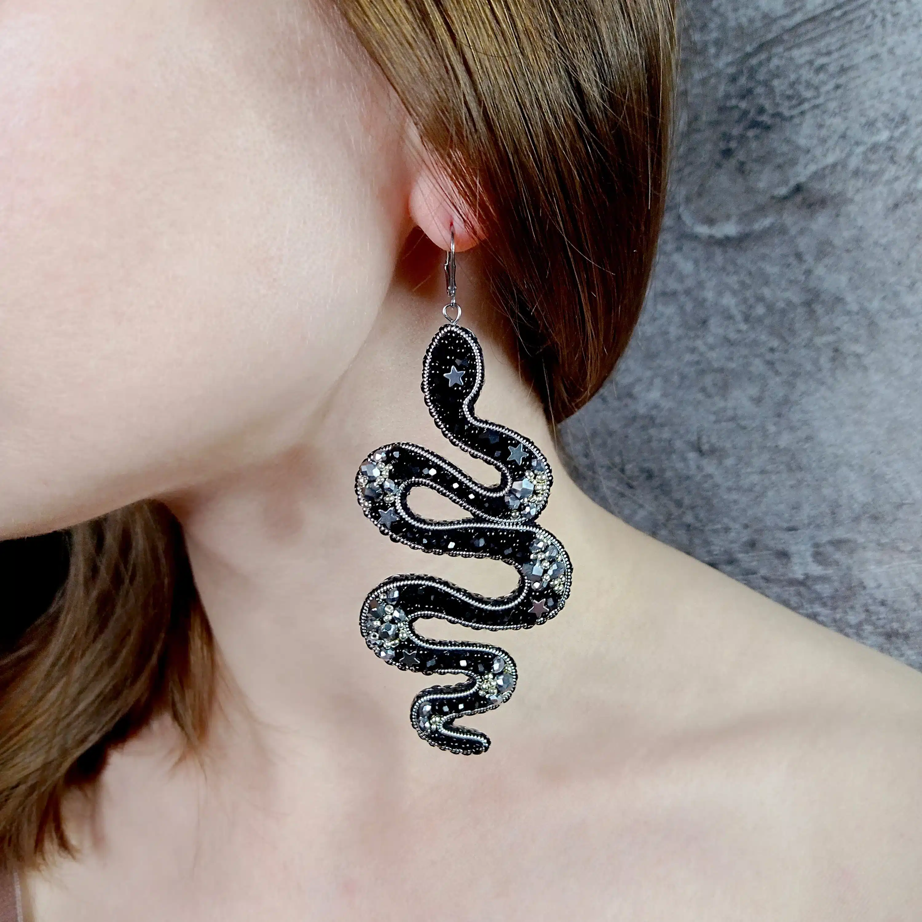 close up of a girl wearing snake earring close up of a girl wearing snake earring