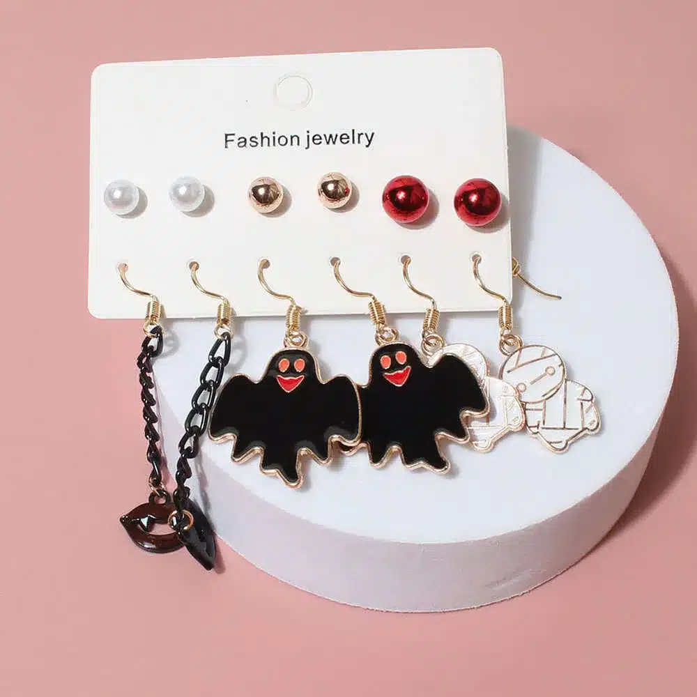 different shapes of halloween earrings on a pink background different shapes of halloween earrings on a pink background