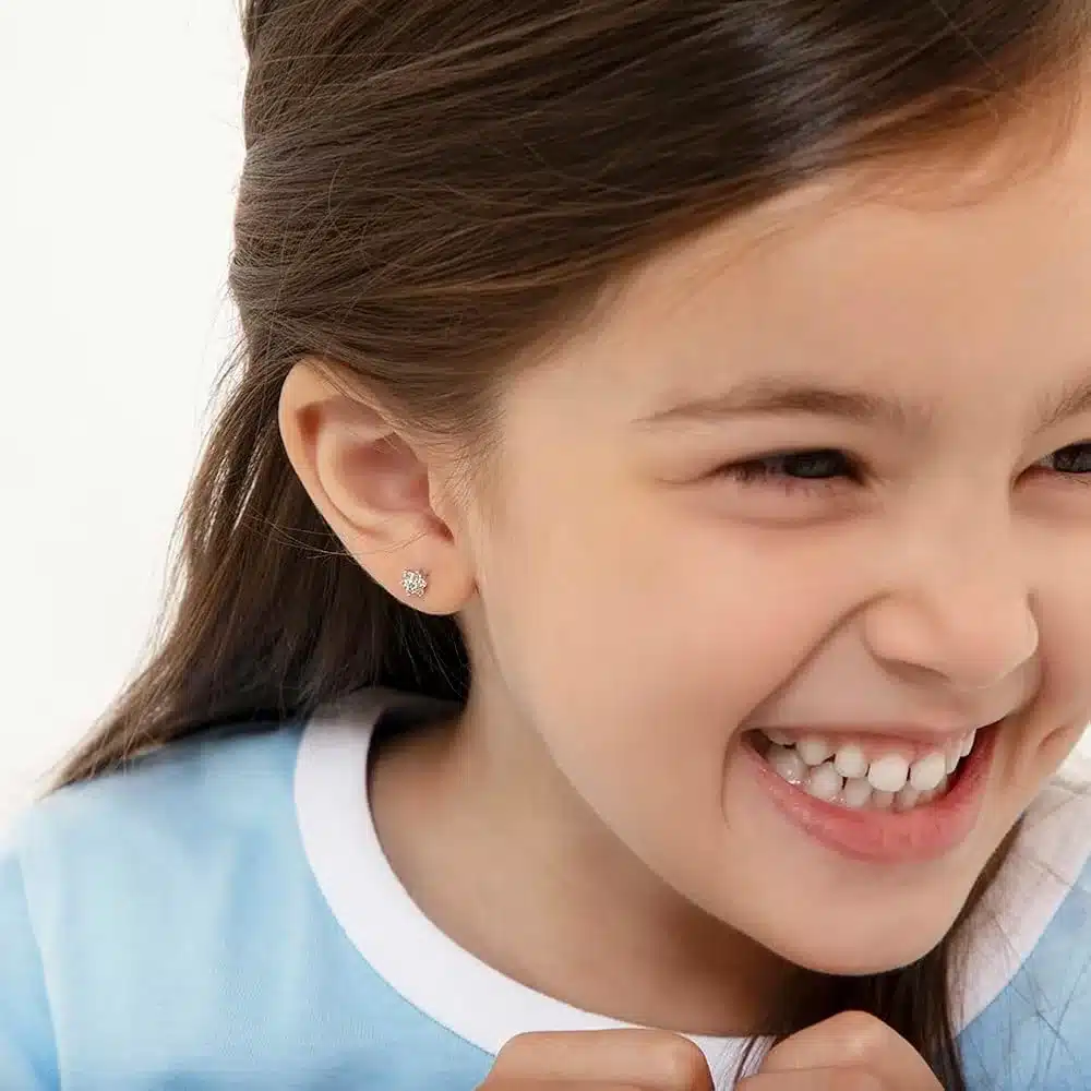 a baby girl happily smiling a stud in her ear