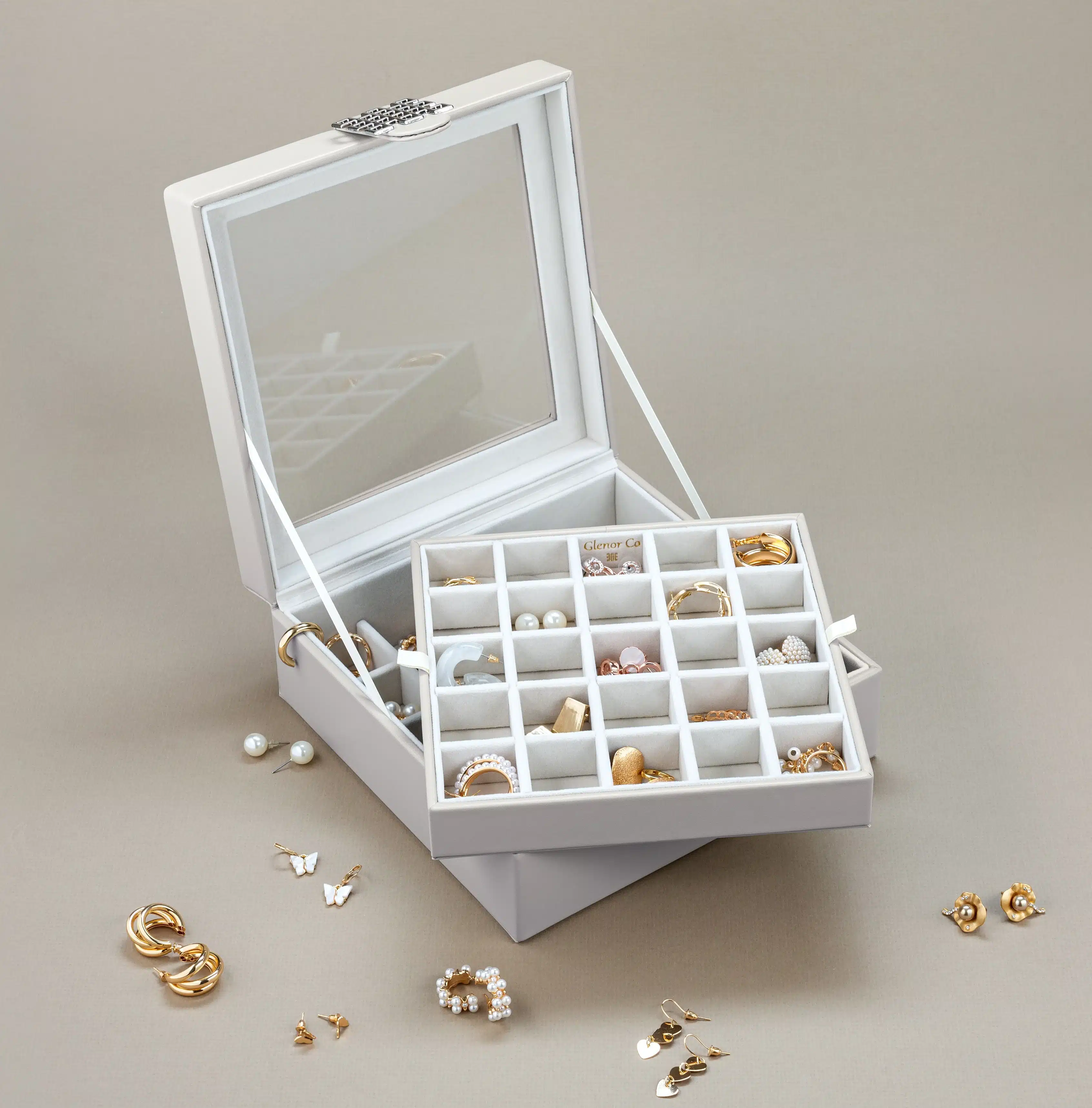 a white colored jewelry box earrings organized in it a white colored jewelry box earrings organized in it