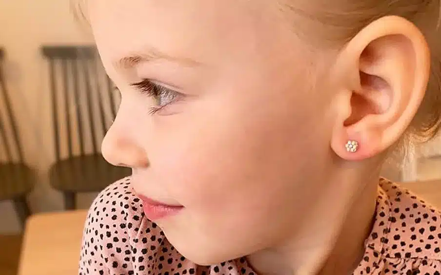 close up of a baby with medical grade earring