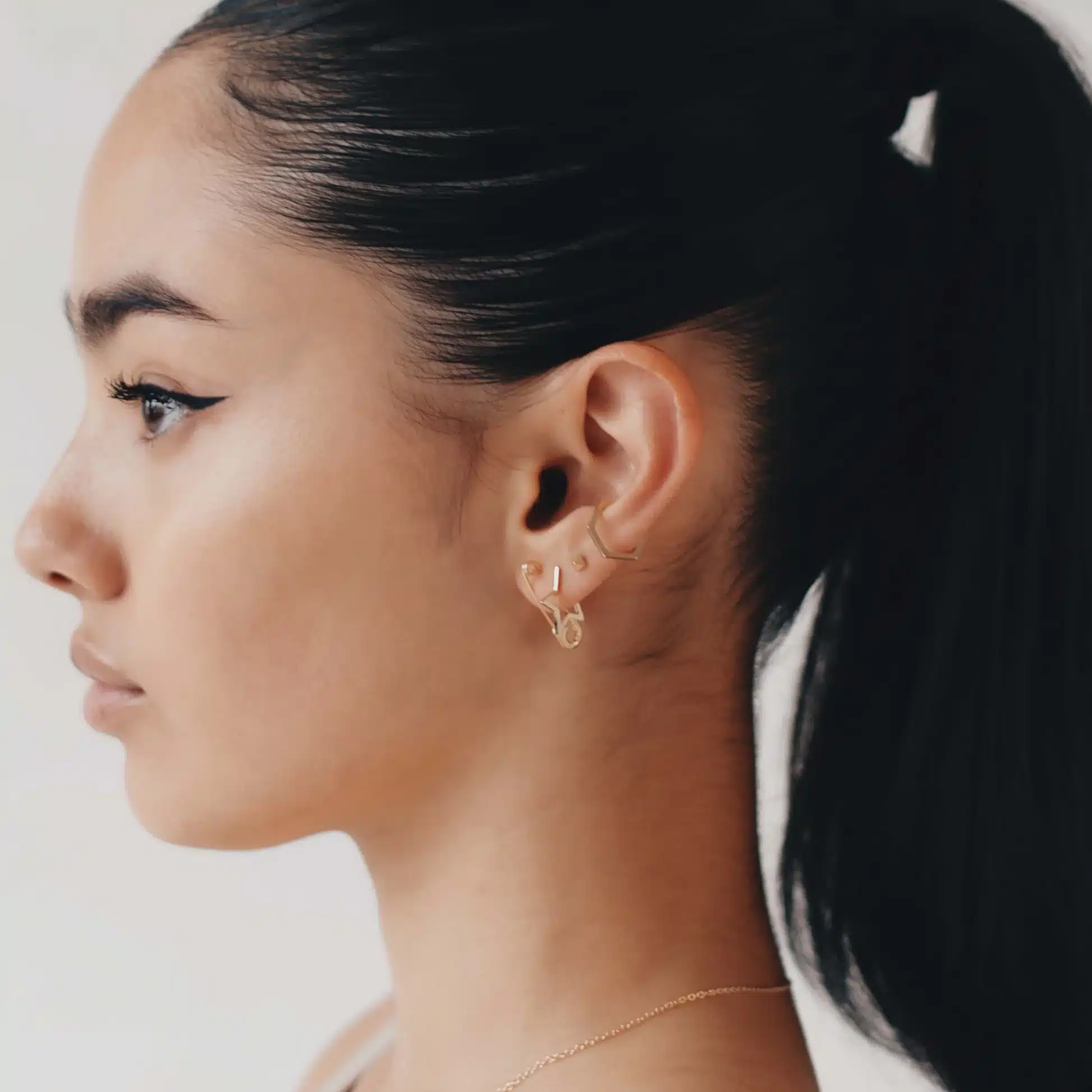 side pose of a girl wearing safety pin earring