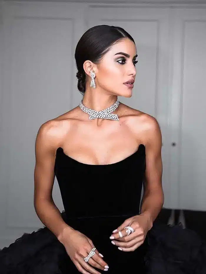 Elegant woman wearing diamond jewelry including earrings necklace and rings with a strapless black dress ( )