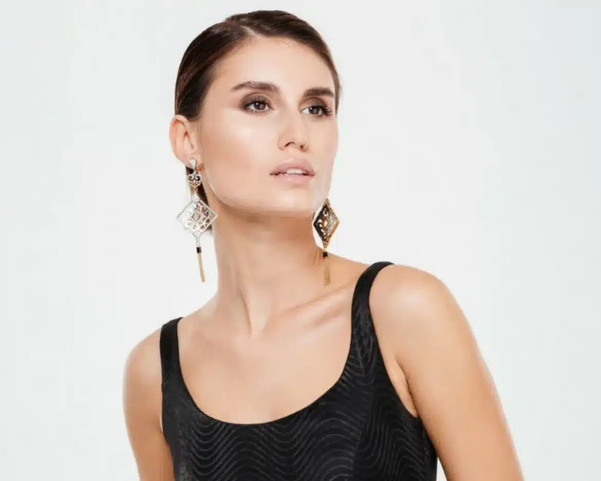 a cute girl with long earrings on a white background
