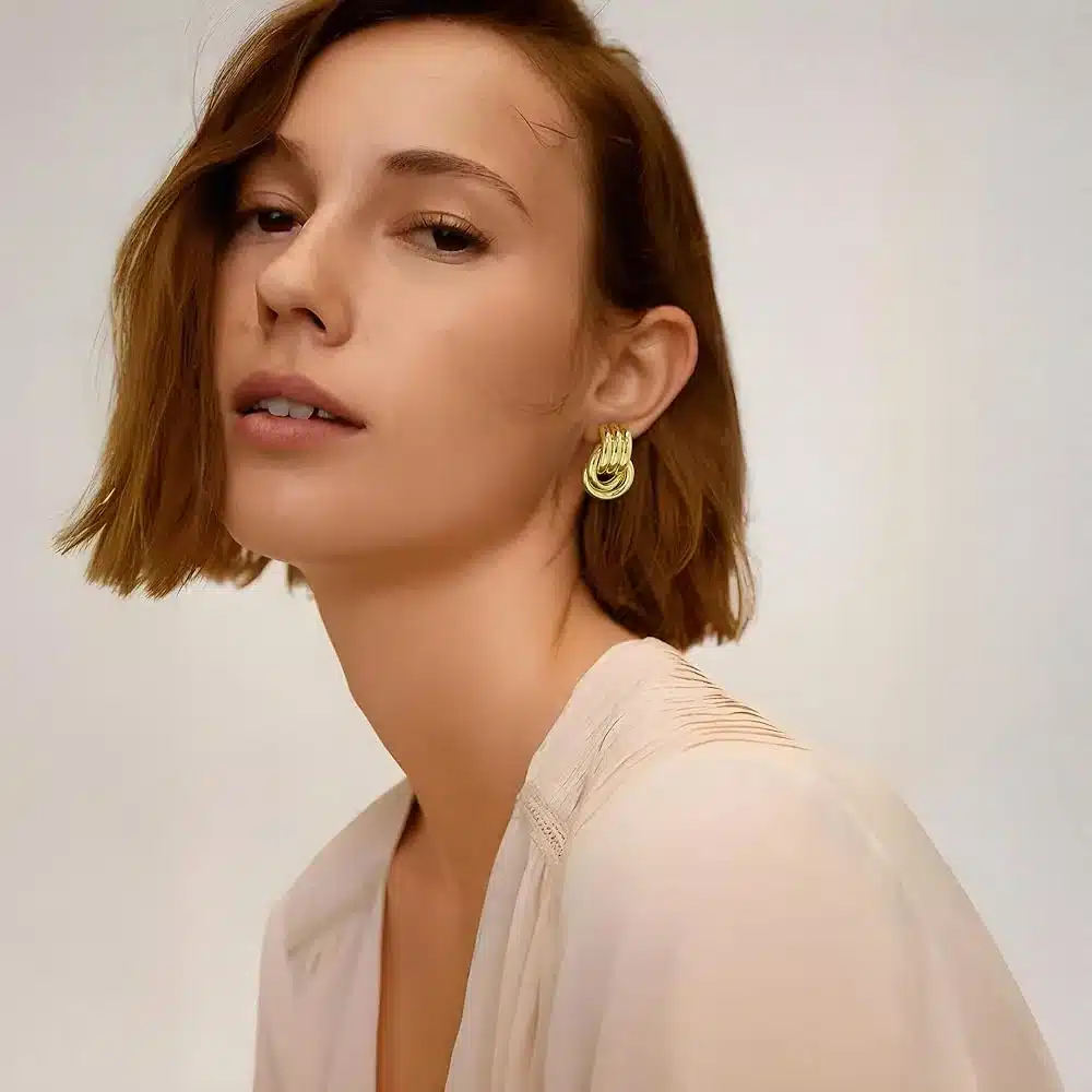 a girl with bob haircut wearing golden chunky earrings