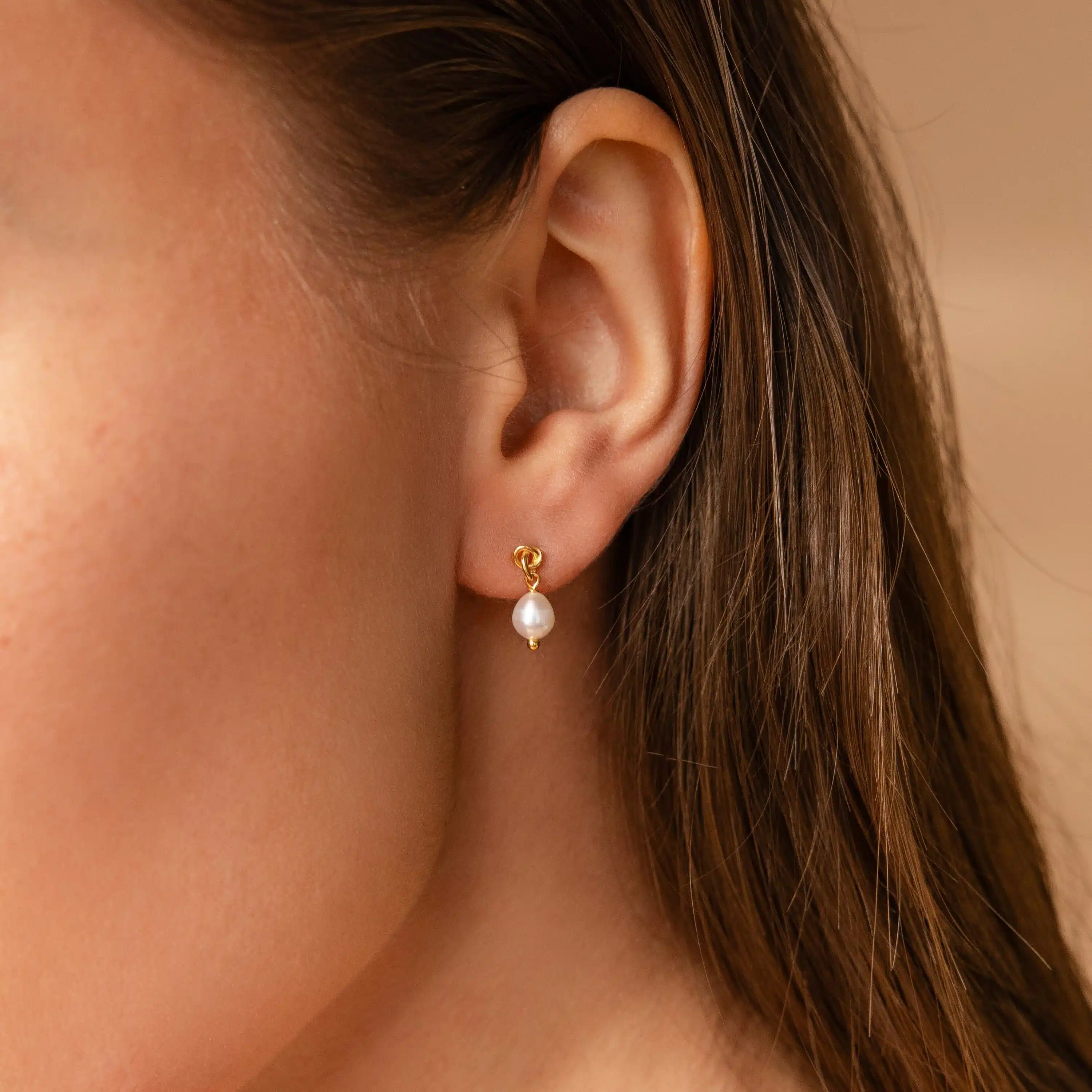 close up of a girl's ear wearing dainty earring