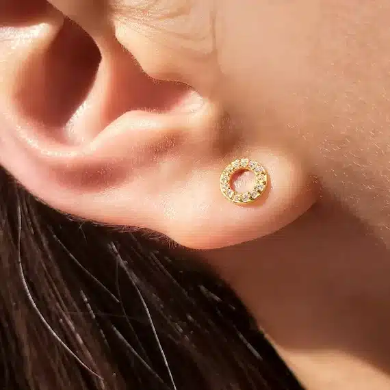 close up of a girl's ear wearing stud earring